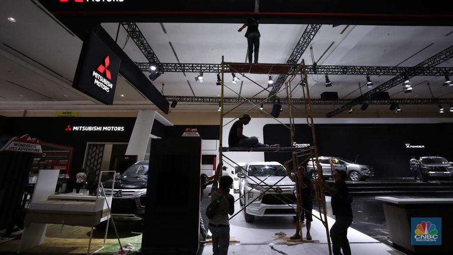 Pekerja menyelesaikan dekorasi booth pameran Gabungan Industri Kendaraan Bermotor Indonesia (Gaikindo) Auto Week Jakarta di Jakarta Convention Center (JCC), Kamis (9/3/2023). (CNBC Indonesia/Tri Susilo)