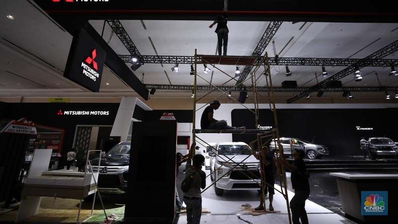 Pekerja menyelesaikan dekorasi booth pameran Gabungan Industri Kendaraan Bermotor Indonesia (Gaikindo) Auto Week Jakarta di Jakarta Convention Center (JCC), Kamis (9/3/2023). (CNBC Indonesia/Tri Susilo)