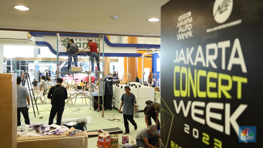 Pekerja menyelesaikan dekorasi booth pameran Gabungan Industri Kendaraan Bermotor Indonesia (Gaikindo) Auto Week Jakarta di Jakarta Convention Center (JCC), Kamis (9/3/2023). (CNBC Indonesia/Tri Susilo)