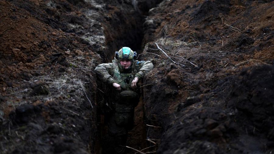 Seorang prajurit Ukraina bersembunyi di parit dekat kota garis depan Bakhmut di tengah serangan Rusia di Ukraina, wilayah Donetsk, Ukraina 8 Maret 2023. (REUTERS/LISI NIESNER)