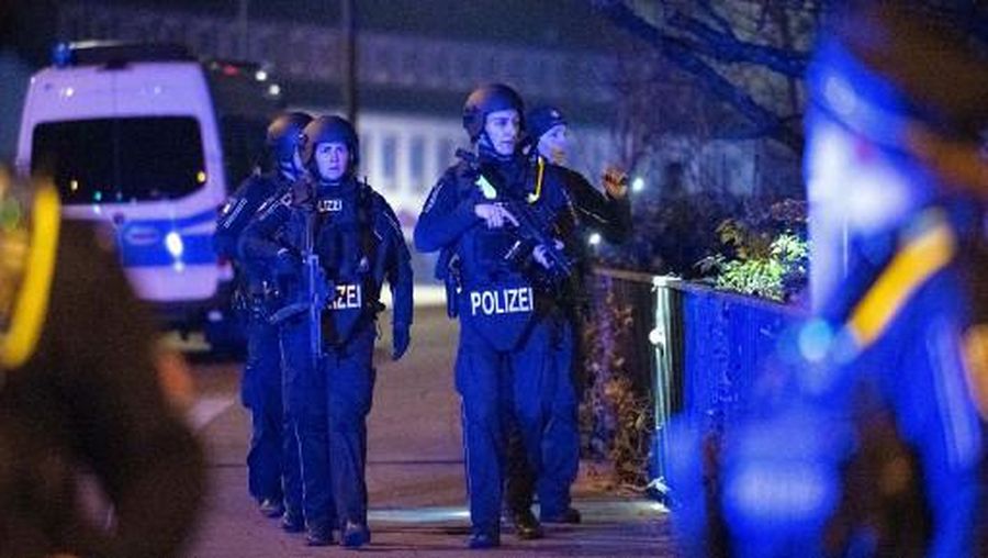 Heavily armed police inspect the area near a Jehovah's Witness church where several people have been killed in a shooting in Hamburg, northern Germany, on late March 9, 2023. - The shooting took place at around 9pm, police said, adding that there were 