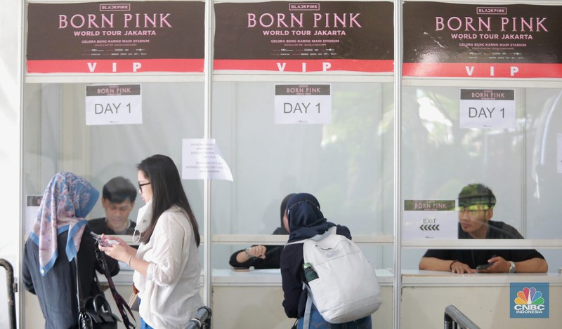 Pengunjung berfoto di depan banner penukaran tiket Blackpink, di Senayan, Jakarta, Jumat, 10/3. Seperti diketahui konser BLACKPINK akan digelar besok selama dua hari di Stadion Utama Gelora Bung Karno, yakni pada 11 dan 12 Maret 2023 mendatang. (CNBC Indonesia/ Muhammad Sabki)
