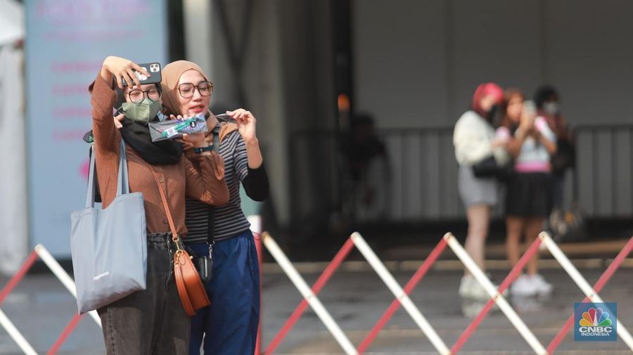 Pengunjung berfoto di depan banner penukaran tiket Blackpink, di Senayan, Jakarta, Jumat, 10/3. Seperti diketahui konser BLACKPINK akan digelar besok selama dua hari di Stadion Utama Gelora Bung Karno, yakni pada 11 dan 12 Maret 2023 mendatang. (CNBC Indonesia/ Muhammad Sabki)