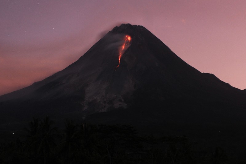 1248048336 Lava spews out of Mount Merapi, Indonesia's most active volcano, as seen from the Kaliurang Selatan village in Srumbung, Magelang, Central Java on March 12, 2023. (Photo by DEVI RAHMAN / AFP) (Photo by DEVI RAHMAN/AFP via Getty Images)