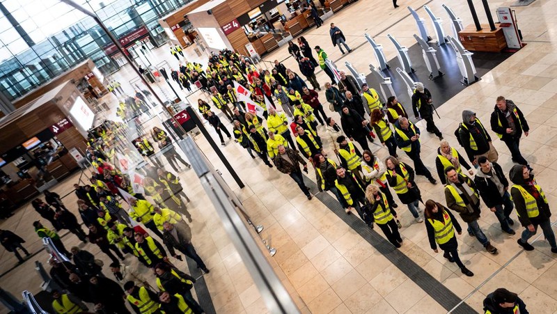 Petugas keamanan yang mogok berkumpul di luar aula Terminal 1 di Bandara Berlin Brandenburg pada 13 Maret 2023 di Schoenefeld, Jerman. Personil keamanan di bandara Berlin, Bremen, Hamburg dan Hanover hari ini mogok untuk menuntut upah yang lebih tinggi. Pekerja sektor publik dari berbagai profesi melakukan pemogokan di seluruh Jerman minggu ini dalam upaya Ver.di, serikat pekerja yang mewakili mereka, untuk menekan pemberi kerja dalam negosiasi upah yang sedang berlangsung. (Sean Gallup/Getty Images)