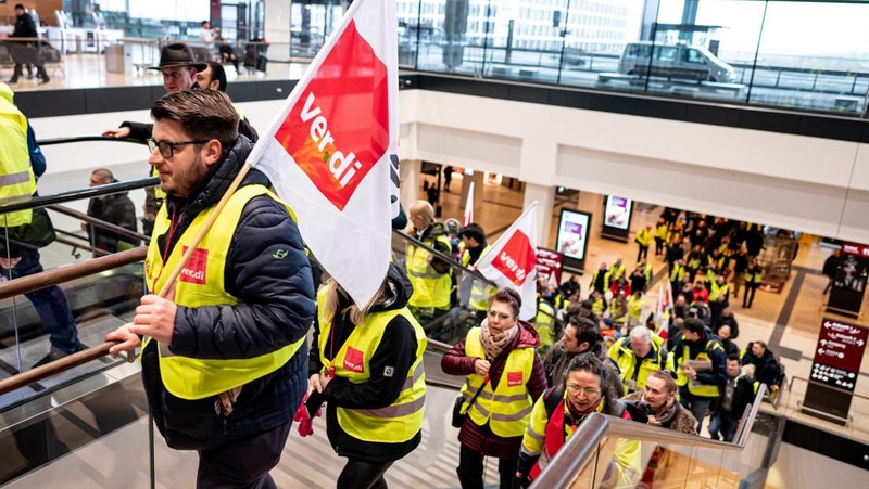 Petugas keamanan yang mogok berkumpul di luar aula Terminal 1 di Bandara Berlin Brandenburg pada 13 Maret 2023 di Schoenefeld, Jerman. Personil keamanan di bandara Berlin, Bremen, Hamburg dan Hanover hari ini mogok untuk menuntut upah yang lebih tinggi. Pekerja sektor publik dari berbagai profesi melakukan pemogokan di seluruh Jerman minggu ini dalam upaya Ver.di, serikat pekerja yang mewakili mereka, untuk menekan pemberi kerja dalam negosiasi upah yang sedang berlangsung. (Sean Gallup/Getty Images)