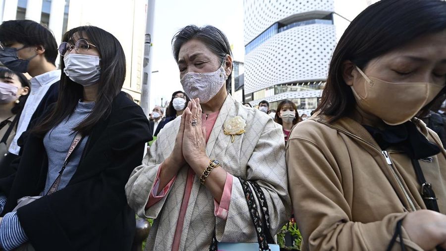 Orang-orang berkumpul di Natori, Prefektur Miyagi, Jepang untuk mengenang para korban pada peringatan 12 tahun gempa bumi, tsunami, dan bencana nuklir 2011. (JIJI PRESS/AFP via Getty Images/STR)