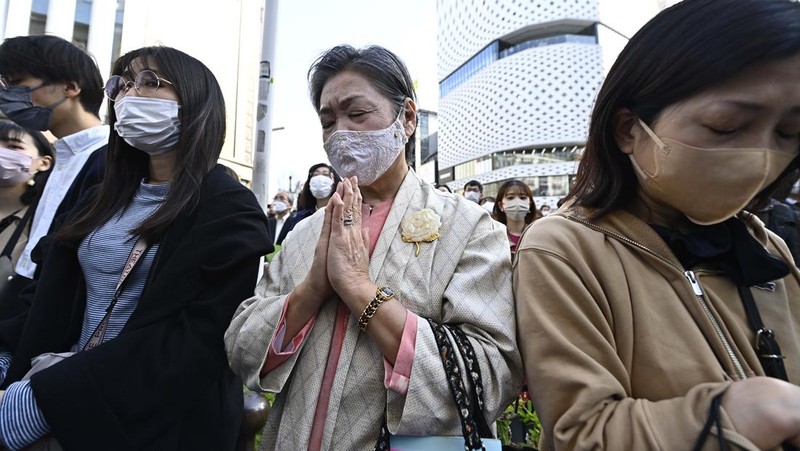 Orang-orang berkumpul di Natori, Prefektur Miyagi, Jepang untuk mengenang para korban pada peringatan 12 tahun gempa bumi, tsunami, dan bencana nuklir 2011. (JIJI PRESS/AFP via Getty Images/STR)