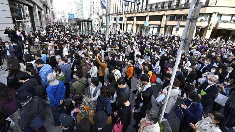 Orang-orang berkumpul di Natori, Prefektur Miyagi, Jepang untuk mengenang para korban pada peringatan 12 tahun gempa bumi, tsunami, dan bencana nuklir 2011. (JIJI PRESS/AFP via Getty Images/STR)