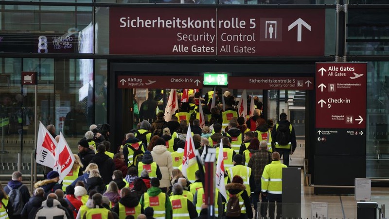 Petugas keamanan yang mogok berkumpul di luar aula Terminal 1 di Bandara Berlin Brandenburg pada 13 Maret 2023 di Schoenefeld, Jerman. Personil keamanan di bandara Berlin, Bremen, Hamburg dan Hanover hari ini mogok untuk menuntut upah yang lebih tinggi. Pekerja sektor publik dari berbagai profesi melakukan pemogokan di seluruh Jerman minggu ini dalam upaya Ver.di, serikat pekerja yang mewakili mereka, untuk menekan pemberi kerja dalam negosiasi upah yang sedang berlangsung. (Sean Gallup/Getty Images)