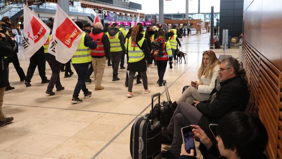 Petugas keamanan yang mogok berkumpul di luar aula Terminal 1 di Bandara Berlin Brandenburg pada 13 Maret 2023 di Schoenefeld, Jerman. Personil keamanan di bandara Berlin, Bremen, Hamburg dan Hanover hari ini mogok untuk menuntut upah yang lebih tinggi. Pekerja sektor publik dari berbagai profesi melakukan pemogokan di seluruh Jerman minggu ini dalam upaya Ver.di, serikat pekerja yang mewakili mereka, untuk menekan pemberi kerja dalam negosiasi upah yang sedang berlangsung. (Sean Gallup/Getty Images)