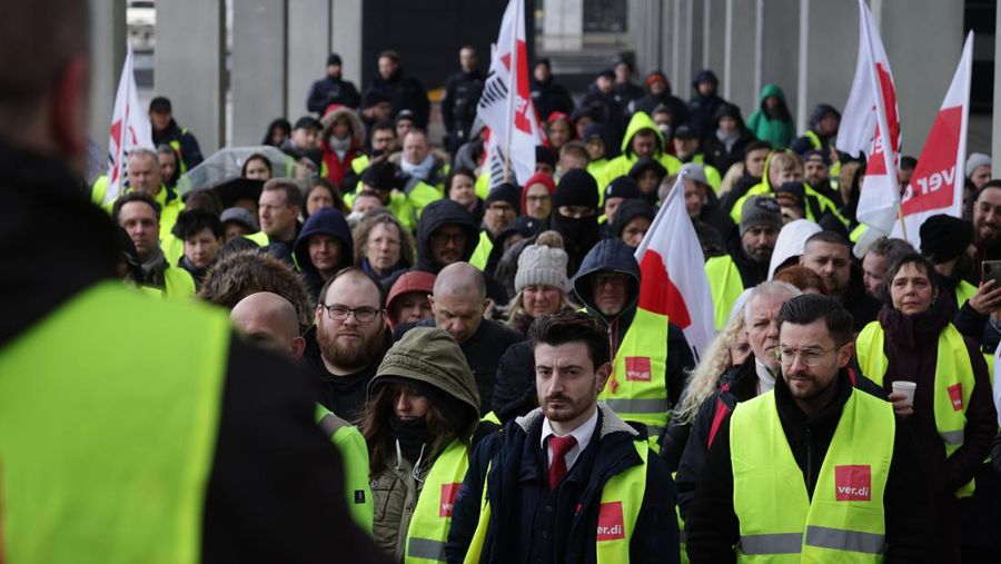 Petugas keamanan yang mogok berkumpul di luar aula Terminal 1 di Bandara Berlin Brandenburg pada 13 Maret 2023 di Schoenefeld, Jerman. Personil keamanan di bandara Berlin, Bremen, Hamburg dan Hanover hari ini mogok untuk menuntut upah yang lebih tinggi. Pekerja sektor publik dari berbagai profesi melakukan pemogokan di seluruh Jerman minggu ini dalam upaya Ver.di, serikat pekerja yang mewakili mereka, untuk menekan pemberi kerja dalam negosiasi upah yang sedang berlangsung. (Sean Gallup/Getty Images)