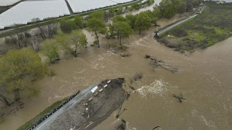 Tangkapan layar dari video menunjukkan tanggul jebol dan sungai banjir di Pajaro, California, AS, 12 Maret 2023. (REUTERS/DRONE BASE)