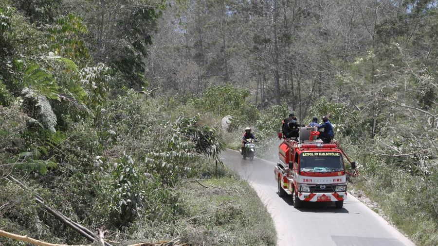 Firefighters clean a school road from dust after Mount Merapi erupted in Boyolali, Central Java on March 13, 2023. (Photo by DIKA / AFP) (Photo by DIKA/AFP via Getty Images)