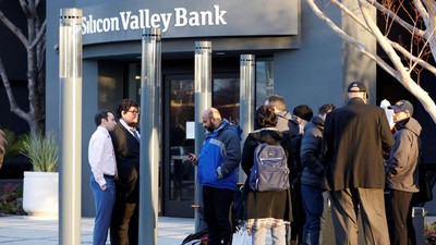 GLOBAL-BANKS/SVB FDIC representatives Luis Mayorga and Igor Fayermark speak with customers outside of the Silicon Valley Bank headquarters in Santa Clara, California, U.S. March 13, 2023. REUTERS/Brittany Hosea-Small