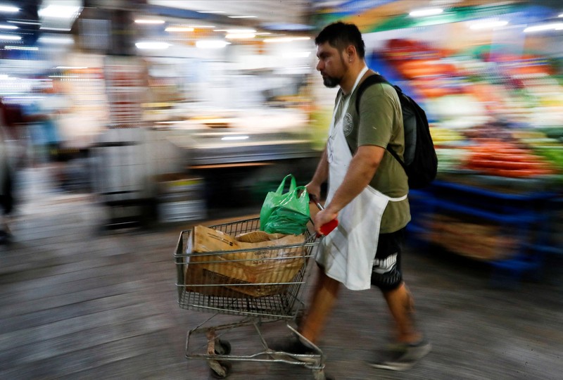 ARGENTINA-INFLATION/ A butcher walks with a shopping cart at a local market, as Argentina's annual inflation rate tore past 100% in February, the country's statistics agency said on Tuesday, the first time it has hit triple figures since a period of hyperinflation in 1991, over three decades ago, in Buenos Aires, Argentina March 14, 2023. REUTERS/Agustin Marcarian TPX IMAGES OF THE DAY