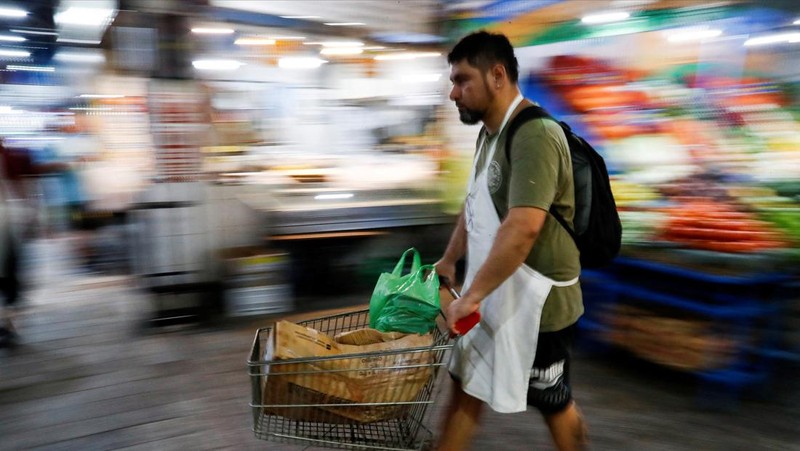 A butcher walks with a shopping cart at a local market, as Argentina's annual inflation rate tore past 100% in February, the country's statistics agency said on Tuesday, the first time it has hit triple figures since a period of hyperinflation in 1991, over three decades ago, in Buenos Aires, Argentina March 14, 2023. REUTERS/Agustin Marcarian     TPX IMAGES OF THE DAY