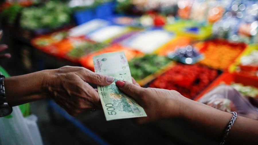 A costumer pays at a greengrocery store in a local market, as Argentina's annual inflation rate tore past 100% in February, the country's statistics agency said on Tuesday, the first time it has hit triple figures since a period of hyperinflation in 1991, over three decades ago, in Buenos Aires, Argentina March 14, 2023. REUTERS/Agustin Marcarian