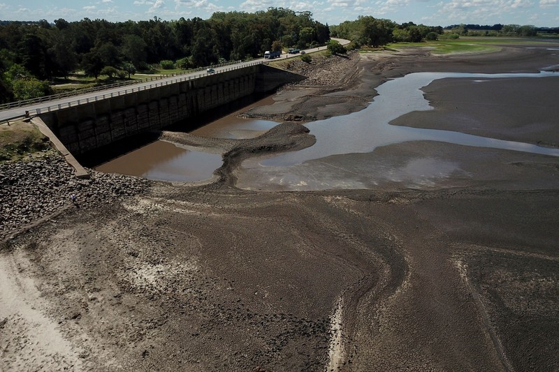 Seorang pria memotret waduk Canelon Grande yang kering di utara Canelones, Uruguay selatan, pada 14 Maret 2023, saat negara itu mengalami kekeringan parah. Seorang pria memotret waduk Canelon Grande yang kering di utara Canelones, Uruguay selatan, pada 14 Maret 2023, saat negara itu mengalami kekeringan parah. - Tujuan utama waduk adalah untuk memasok air minum ke wilayah Metropolitan Montevideo, selain itu juga digunakan dalam sistem irigasi di daerah tersebut. (PABLO PORCIUNCULA/AFP via Getty Images)
