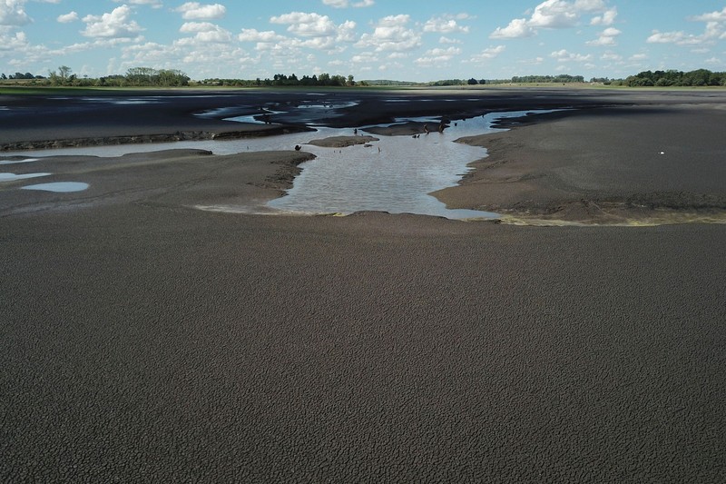 Seorang pria memotret waduk Canelon Grande yang kering di utara Canelones, Uruguay selatan, pada 14 Maret 2023, saat negara itu mengalami kekeringan parah. Seorang pria memotret waduk Canelon Grande yang kering di utara Canelones, Uruguay selatan, pada 14 Maret 2023, saat negara itu mengalami kekeringan parah. - Tujuan utama waduk adalah untuk memasok air minum ke wilayah Metropolitan Montevideo, selain itu juga digunakan dalam sistem irigasi di daerah tersebut. (PABLO PORCIUNCULA/AFP via Getty Images)