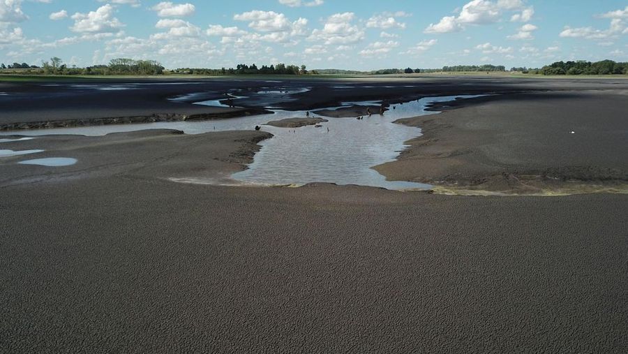 Seorang pria memotret waduk Canelon Grande yang kering di utara Canelones, Uruguay selatan, pada 14 Maret 2023, saat negara itu mengalami kekeringan parah. - Tujuan utama waduk adalah untuk memasok air minum ke wilayah Metropolitan Montevideo, selain itu juga digunakan dalam sistem irigasi di daerah tersebut. (PABLO PORCIUNCULA/AFP via Getty Images)