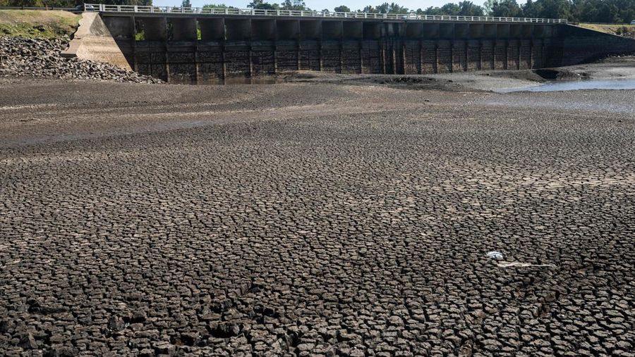 Seorang pria memotret waduk Canelon Grande yang kering di utara Canelones, Uruguay selatan, pada 14 Maret 2023, saat negara itu mengalami kekeringan parah. - Tujuan utama waduk adalah untuk memasok air minum ke wilayah Metropolitan Montevideo, selain itu juga digunakan dalam sistem irigasi di daerah tersebut. (PABLO PORCIUNCULA/AFP via Getty Images)