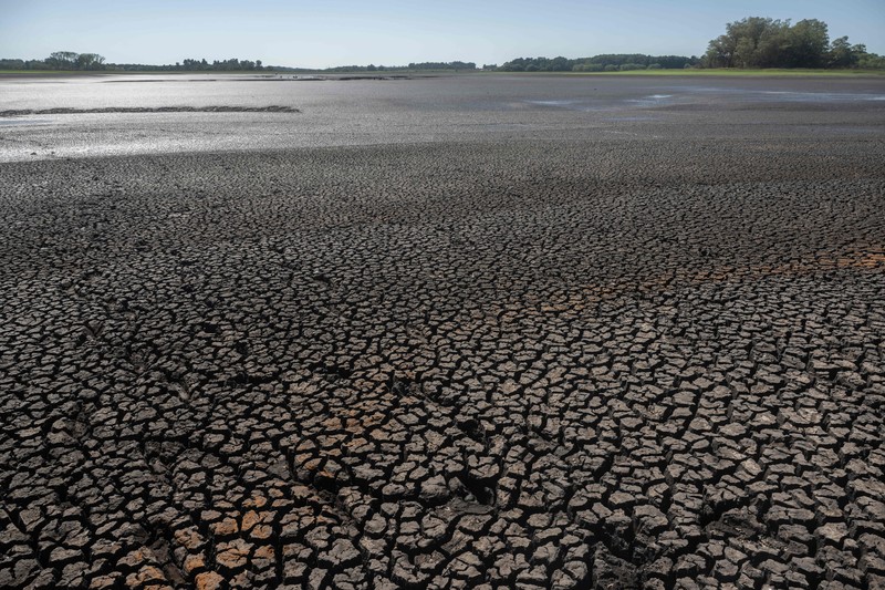 Seorang pria memotret waduk Canelon Grande yang kering di utara Canelones, Uruguay selatan, pada 14 Maret 2023, saat negara itu mengalami kekeringan parah. Seorang pria memotret waduk Canelon Grande yang kering di utara Canelones, Uruguay selatan, pada 14 Maret 2023, saat negara itu mengalami kekeringan parah. - Tujuan utama waduk adalah untuk memasok air minum ke wilayah Metropolitan Montevideo, selain itu juga digunakan dalam sistem irigasi di daerah tersebut. (PABLO PORCIUNCULA/AFP via Getty Images)
