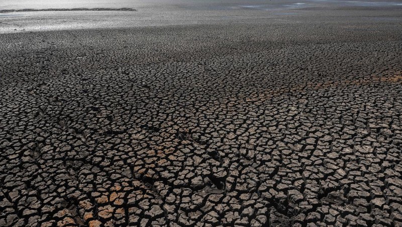 Seorang pria memotret waduk Canelon Grande yang kering di utara Canelones, Uruguay selatan, pada 14 Maret 2023, saat negara itu mengalami kekeringan parah. - Tujuan utama waduk adalah untuk memasok air minum ke wilayah Metropolitan Montevideo, selain itu juga digunakan dalam sistem irigasi di daerah tersebut. (PABLO PORCIUNCULA/AFP via Getty Images)