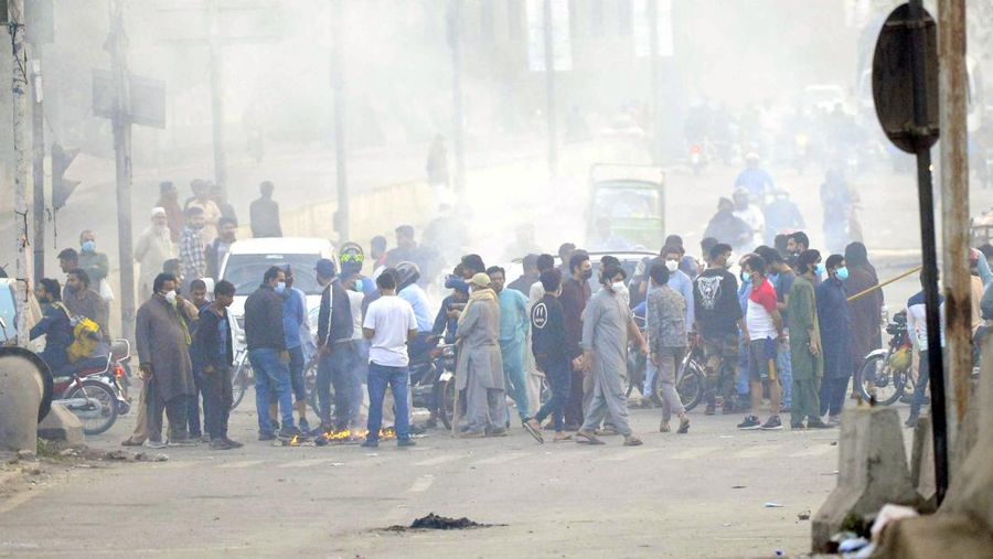 Polisi anti huru hara mencoba memukul mundur pendukung mantan perdana menteri Imran Khan yang berkumpul di luar rumah Khan untuk mencegah petugas menangkapnya, di Lahore, Pakistan pada 14 Maret 2023. Para pengunjuk rasa bentrok dengan polisi. Polisi, yang mengenakan pakaian anti huru hara dan memegang perisai, menggunakan meriam air untuk menghalau para aktivis pelempar batu dari partai Pakistan Tehreek-e-Insaf (PTI) Khan, yang telah menguasai pintu masuk utama ke kediaman pemimpin partai mereka. Beberapa pekerja PTI, menurut sumber kepolisian, ditahan. (Rana Irfan Ali/Anadolu Agency via Getty Images)