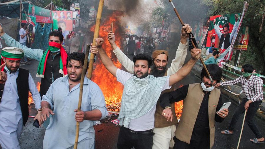 Pendukung mantan Perdana Menteri Pakistan Imran Khan, bereaksi ketika mereka memblokir jalan selama bentrokan, menjelang kemungkinan penangkapan Khan di luar rumahnya, di Lahore, Pakistan 14 Maret 2023. (REUTERS/Mohsin Raza)