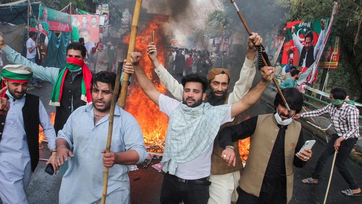 Pendukung mantan Perdana Menteri Pakistan Imran Khan, bereaksi ketika mereka memblokir jalan selama bentrokan, menjelang kemungkinan penangkapan Khan di luar rumahnya, di Lahore, Pakistan 14 Maret 2023. (REUTERS/Mohsin Raza)