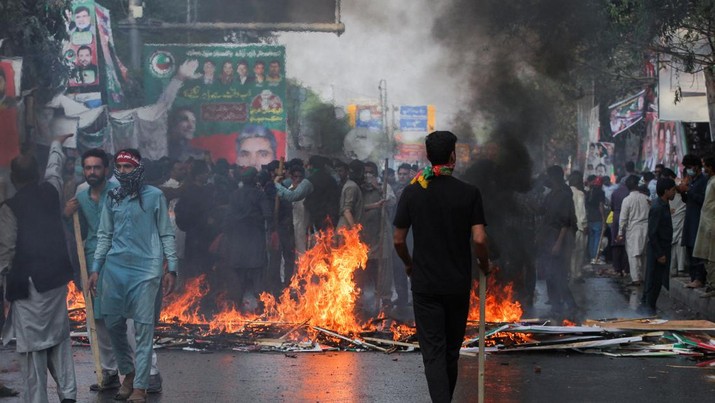 Pendukung mantan Perdana Menteri Pakistan Imran Khan membakar untuk memblokir jalan selama bentrokan dengan polisi menjelang kemungkinan Khan ditangkap di luar rumahnya, di Lahore, Pakistan 14 Maret 2023. (REUTERS/Mohsin Raza)