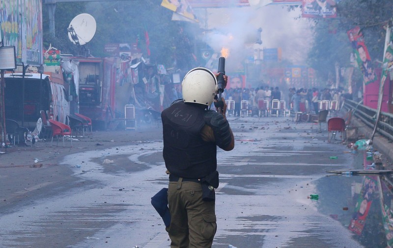 Polisi anti huru hara mencoba memukul mundur pendukung mantan perdana menteri Imran Khan yang berkumpul di luar rumah Khan untuk mencegah petugas menangkapnya, di Lahore, Pakistan pada 14 Maret 2023. Polisi anti huru hara mencoba memukul mundur pendukung mantan perdana menteri Imran Khan yang berkumpul di luar rumah Khan untuk mencegah petugas menangkapnya, di Lahore, Pakistan pada 14 Maret 2023. Para pengunjuk rasa bentrok dengan polisi. Polisi, yang mengenakan pakaian anti huru hara dan memegang perisai, menggunakan meriam air untuk menghalau para aktivis pelempar batu dari partai Pakistan Tehreek-e-Insaf (PTI) Khan, yang telah menguasai pintu masuk utama ke kediaman pemimpin partai mereka. Beberapa pekerja PTI, menurut sumber kepolisian, ditahan. (Rana Irfan Ali/Anadolu Agency via Getty Images)