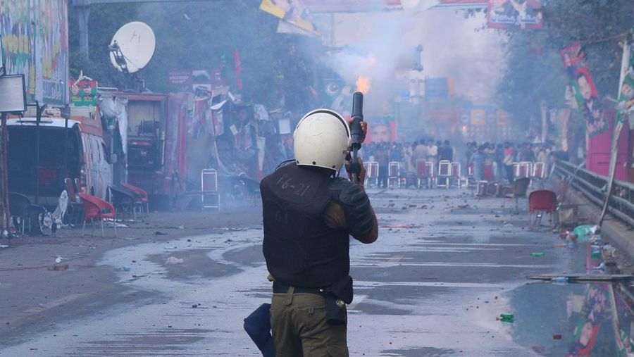 Polisi anti huru hara mencoba memukul mundur pendukung mantan perdana menteri Imran Khan yang berkumpul di luar rumah Khan untuk mencegah petugas menangkapnya, di Lahore, Pakistan pada 14 Maret 2023. Para pengunjuk rasa bentrok dengan polisi. Polisi, yang mengenakan pakaian anti huru hara dan memegang perisai, menggunakan meriam air untuk menghalau para aktivis pelempar batu dari partai Pakistan Tehreek-e-Insaf (PTI) Khan, yang telah menguasai pintu masuk utama ke kediaman pemimpin partai mereka. Beberapa pekerja PTI, menurut sumber kepolisian, ditahan. (Rana Irfan Ali/Anadolu Agency via Getty Images)