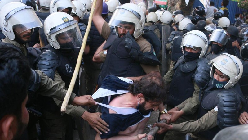 Polisi anti huru hara mencoba memukul mundur pendukung mantan perdana menteri Imran Khan yang berkumpul di luar rumah Khan untuk mencegah petugas menangkapnya, di Lahore, Pakistan pada 14 Maret 2023. Para pengunjuk rasa bentrok dengan polisi. Polisi, yang mengenakan pakaian anti huru hara dan memegang perisai, menggunakan meriam air untuk menghalau para aktivis pelempar batu dari partai Pakistan Tehreek-e-Insaf (PTI) Khan, yang telah menguasai pintu masuk utama ke kediaman pemimpin partai mereka. Beberapa pekerja PTI, menurut sumber kepolisian, ditahan. (Rana Irfan Ali/Anadolu Agency via Getty Images)