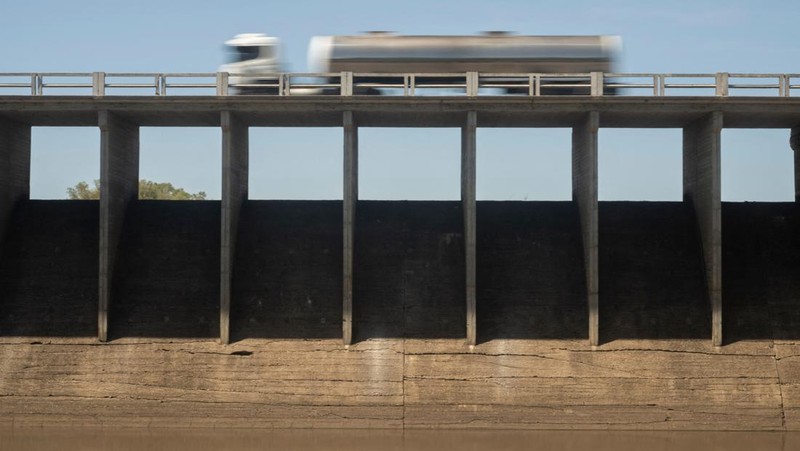 Seorang pria memotret waduk Canelon Grande yang kering di utara Canelones, Uruguay selatan, pada 14 Maret 2023, saat negara itu mengalami kekeringan parah. - Tujuan utama waduk adalah untuk memasok air minum ke wilayah Metropolitan Montevideo, selain itu juga digunakan dalam sistem irigasi di daerah tersebut. (PABLO PORCIUNCULA/AFP via Getty Images)