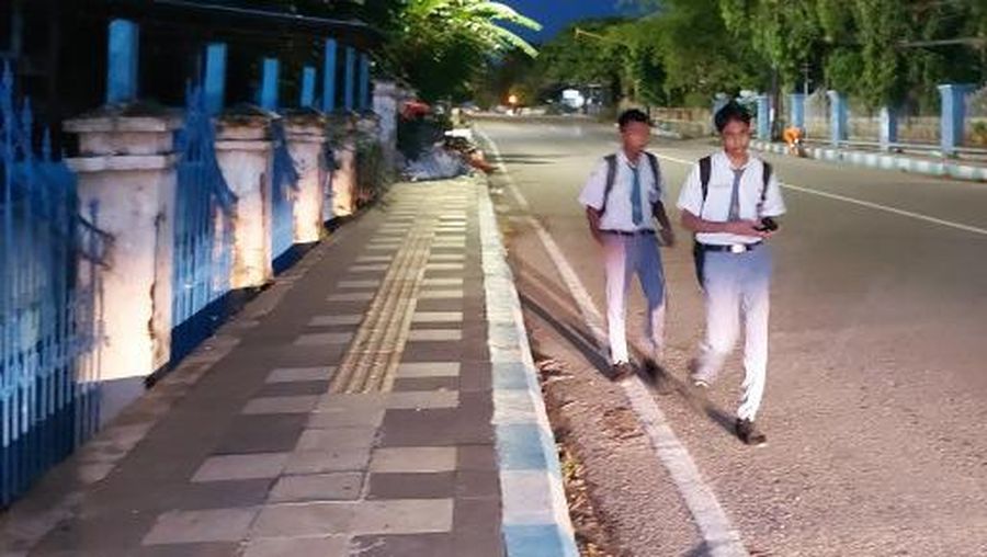 This picture taken on March 6, 2023 shows high school students walking to school early in the morning in Kupang. - A pilot project in Kupang, the capital of East Nusa Tenggara province, has twelfth-graders at 10 high schools starting classes at 5:30 am. (Photo by ELIAZAR BALLO / AFP)