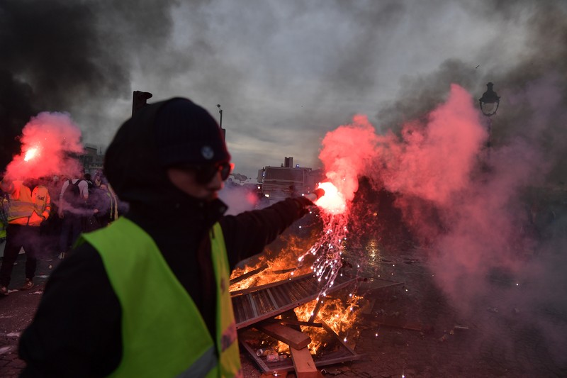 Para pengunjuk rasa membakar saat bentrokan terjadi dengan polisi anti huru hara selama demonstrasi menentang rencana pemerintah Prancis untuk menaikkan usia pensiun resmi di Paris, pada 16 Maret 2023. (Firas Abdullah/Anadolu Agency via Getty Images)