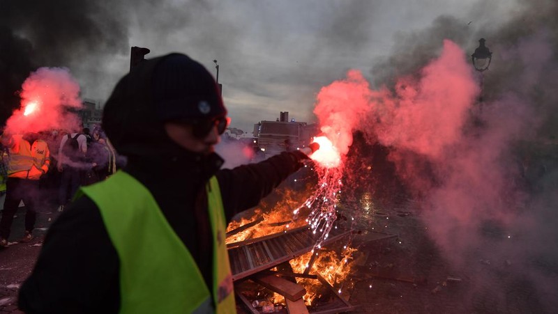 Para pengunjuk rasa membakar saat bentrokan terjadi dengan polisi anti huru hara selama demonstrasi menentang rencana pemerintah Prancis untuk menaikkan usia pensiun resmi di Paris, pada 16 Maret 2023. (Firas Abdullah/Anadolu Agency via Getty Images)