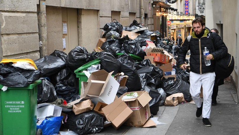 Tong sampah penuh dengan sampah di jalanan saat pemungut melanjutkan pemogokan mereka di Paris, Prancis pada 17 Maret 2023. Pemungut sampah telah bergabung dalam pemogokan besar-besaran di seluruh Prancis menentang rencana reformasi pensiun. (Mustafa Yalcin/Anadolu Agency via Getty Images)
