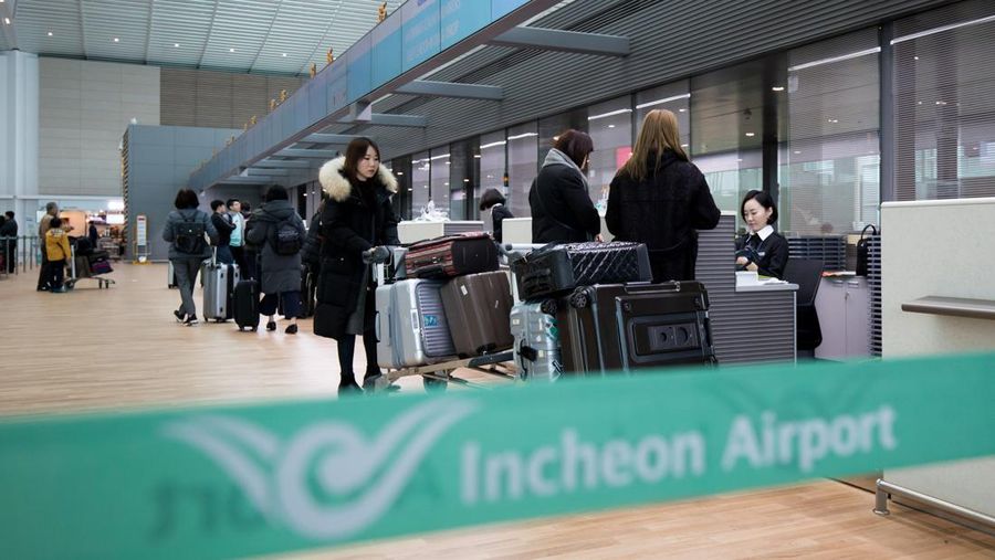 Penumpang berdiri di konter check-in Korean Air Lines Co. di dalam gedung terminal 2 Bandara Internasional Incheon di Incheon, Korea Selatan, Kamis, 18 Januari 2018. Terminal baru dibuka hari ini. (File Foto - SeongJoon Cho/Bloomberg via Getty Images)