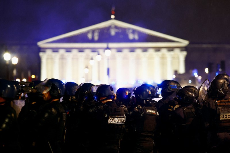 Seorang pengunjuk rasa memegang gambar Presiden Prancis Emmanuel Macron di dekat api selama demonstrasi di Place de la Concorde untuk memprotes penggunaan pasal 49.3 oleh pemerintah Prancis, klausul khusus dalam Konstitusi Prancis, untuk mendorong RUU reformasi pensiun melalui Majelis Nasional tanpa pemungutan suara oleh anggota parlemen, di Paris, Prancis, 17 Maret 2023. Seorang pengunjuk rasa memegang gambar Presiden Prancis Emmanuel Macron di dekat api selama demonstrasi di Place de la Concorde untuk memprotes penggunaan pasal 49.3 oleh pemerintah Prancis, klausul khusus dalam Konstitusi Prancis, untuk mendorong RUU reformasi pensiun melalui Majelis Nasional tanpa pemungutan suara oleh anggota parlemen, di Paris, Prancis, 17 Maret 2023. (REUTERS/Gonzalo Fuentes)