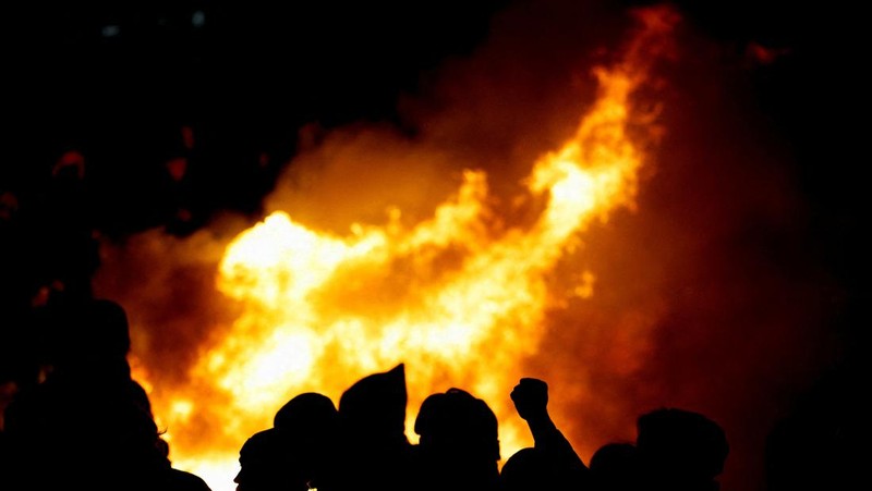 Api muncul ketika orang-orang menghadiri demonstrasi di Place de la Concorde untuk memprotes penggunaan pasal 49.3 oleh pemerintah Prancis, klausul khusus dalam Konstitusi Prancis, untuk mendorong RUU reformasi pensiun melalui Majelis Nasional tanpa pemungutan suara oleh anggota parlemen, di Paris , Prancis, 17 Maret 2023. (REUTERS/Gonzalo Fuentes)
