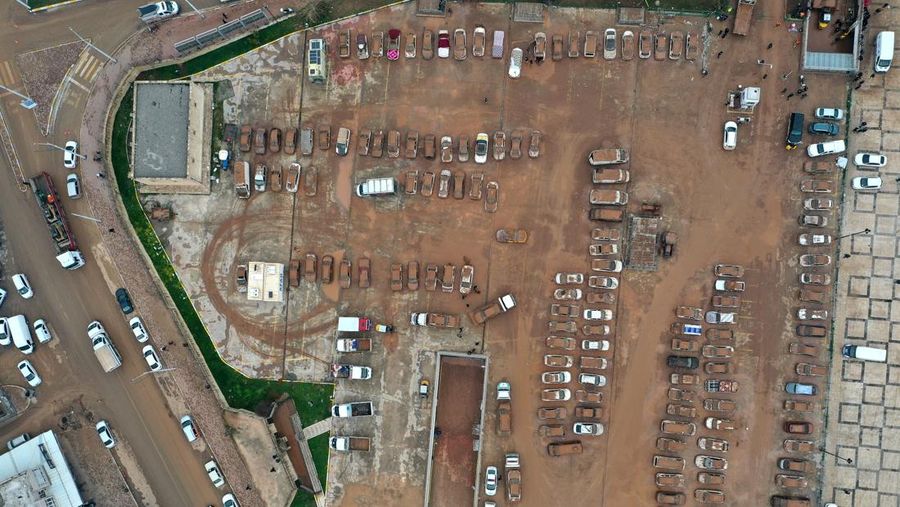 Kendaraan yang terjebak dalam lumpur di tempat parkir yang terendam banjir dekat Museum Arkeologi Sanliurfa dievakuasi, difoto, didokumentasikan, dan diparkir di tempat terbuka setelah hujan lebat menyebabkan banjir di Sanliurfa, Turkiye pada 18 Maret 2023. (Mehmet Akif Parlak/Anadolu Agency via Getty Images)