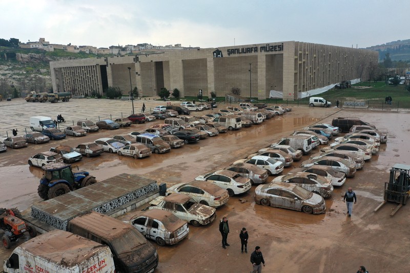 Kendaraan yang terjebak dalam lumpur di tempat parkir yang terendam banjir dekat Museum Arkeologi Sanliurfa dievakuasi, difoto, didokumentasikan, dan diparkir di tempat terbuka setelah hujan lebat menyebabkan banjir di Sanliurfa, Turkiye pada 18 Maret 2023. (Mehmet Akif Parlak/Anadolu Agency via Getty Images)