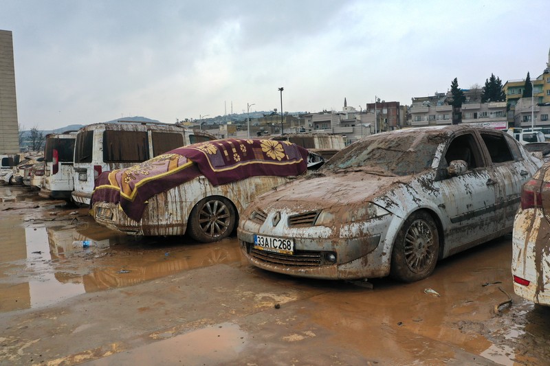 Kendaraan yang terjebak dalam lumpur di tempat parkir yang terendam banjir dekat Museum Arkeologi Sanliurfa dievakuasi, difoto, didokumentasikan, dan diparkir di tempat terbuka setelah hujan lebat menyebabkan banjir di Sanliurfa, Turkiye pada 18 Maret 2023. (Mehmet Akif Parlak/Anadolu Agency via Getty Images)