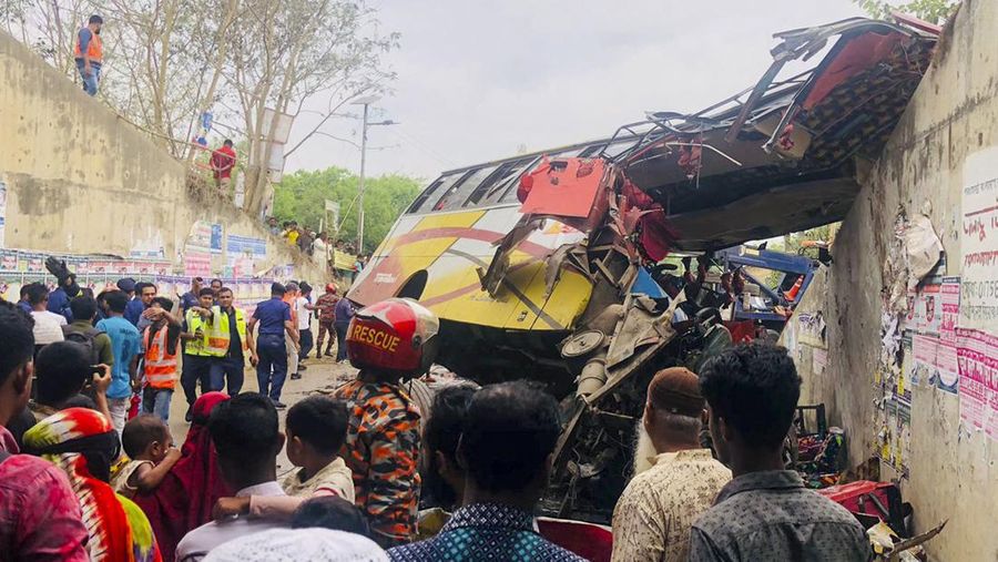 Petugas pemadam kebakaran memadamkan bus yang mengalami kecelakaan di Madaripur pada 19 Maret 2023. - Setidaknya 17 orang tewas dan hingga 25 lainnya luka-luka pada 19 Maret di Bangladesh setelah sebuah bus menabrak pagar jalan raya dan jatuh ke selokan pinggir jalan, menurut polisi. (-/AFP via Getty Images)