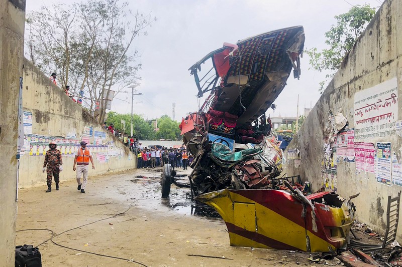 Petugas pemadam kebakaran memadamkan bus yang mengalami kecelakaan di Madaripur pada 19 Maret 2023. - Setidaknya 17 orang tewas dan hingga 25 lainnya luka-luka pada 19 Maret di Bangladesh setelah sebuah bus menabrak pagar jalan raya dan jatuh ke selokan pinggir jalan, menurut polisi. Petugas pemadam kebakaran memadamkan bus yang mengalami kecelakaan di Madaripur pada 19 Maret 2023. - Setidaknya 17 orang tewas dan hingga 25 lainnya luka-luka pada 19 Maret di Bangladesh setelah sebuah bus menabrak pagar jalan raya dan jatuh ke selokan pinggir jalan, menurut polisi. (-/AFP via Getty Images)