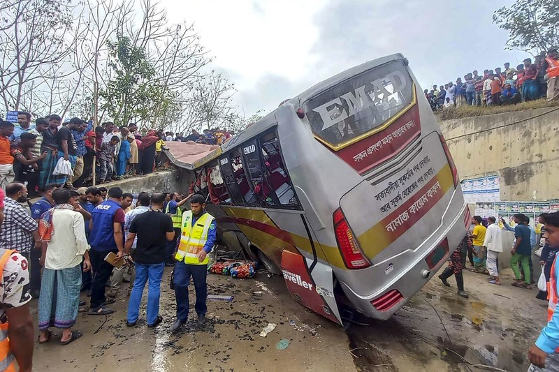 Petugas pemadam kebakaran memadamkan bus yang mengalami kecelakaan di Madaripur pada 19 Maret 2023. - Setidaknya 17 orang tewas dan hingga 25 lainnya luka-luka pada 19 Maret di Bangladesh setelah sebuah bus menabrak pagar jalan raya dan jatuh ke selokan pinggir jalan, menurut polisi. Petugas pemadam kebakaran memadamkan bus yang mengalami kecelakaan di Madaripur pada 19 Maret 2023. - Setidaknya 17 orang tewas dan hingga 25 lainnya luka-luka pada 19 Maret di Bangladesh setelah sebuah bus menabrak pagar jalan raya dan jatuh ke selokan pinggir jalan, menurut polisi. (-/AFP via Getty Images)