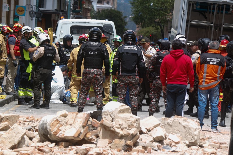 Tim penyelamat bekerja di rumah yang runtuh setelah gempa berkekuatan 6,5 melanda dekat pukul 12:12 siang pada 18 Maret 2023 di Machala, Ekuador. Pusat gempa terletak 6 kilometer utara timur laut Balao, di provinsi El Oro. Sejauh ini pihak berwenang mengkonfirmasi 13 orang tewas. (Jorge Sanchez/Agencia Press South/Getty Images)